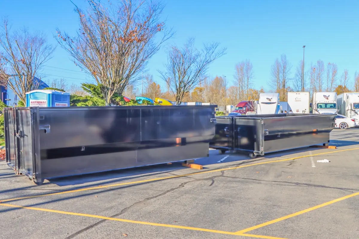 Professional dumpster rental service with roll-off container on residential driveway in Andrews